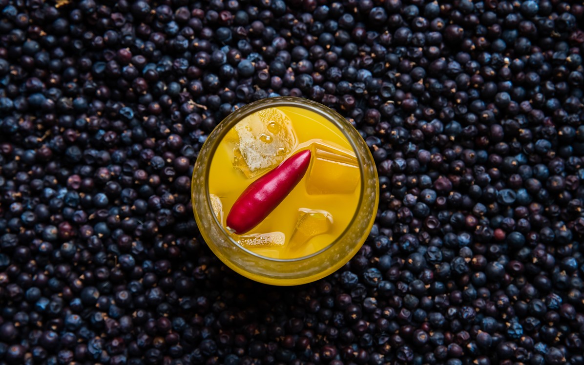 Image of a yellow drink on top of small blue berries