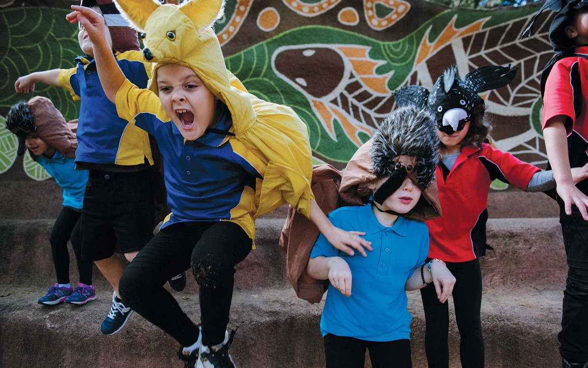 Image of kids dressed in animal costumes jumping off some steps 