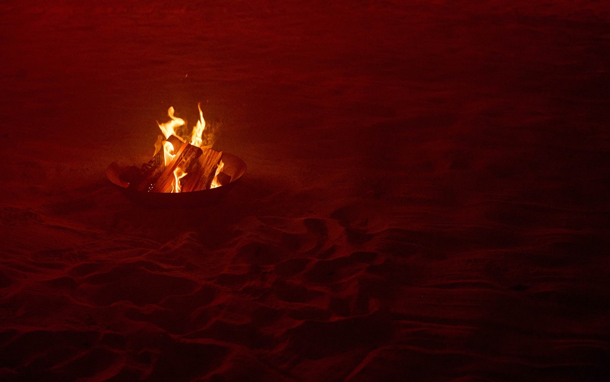a fireplace on sand, very dim hazy red light around