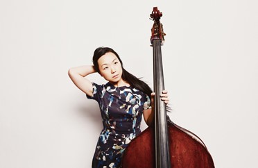 Image of a lady standing and holding a double bass