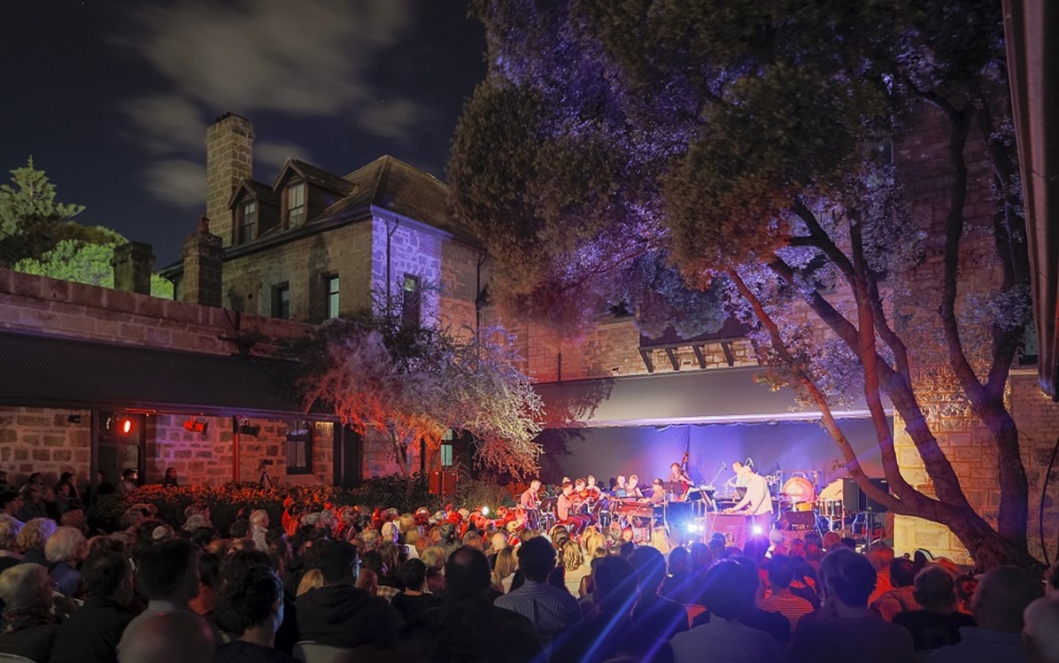 A performance at Fremantle Arts Centre with a full crowd and lighting coming from the stage