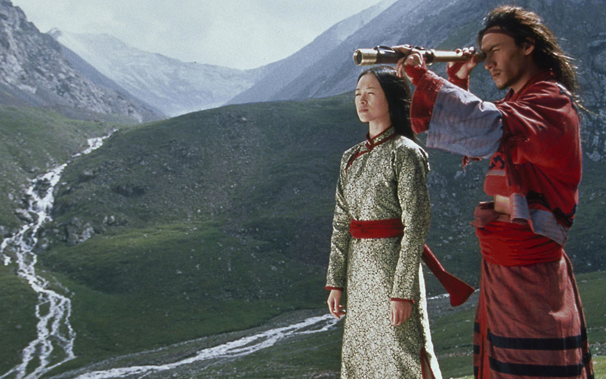 Image of a man and a woman standing on mountains and looking through a telescope from the film ''Crouching Tiger Hidden Dragon"