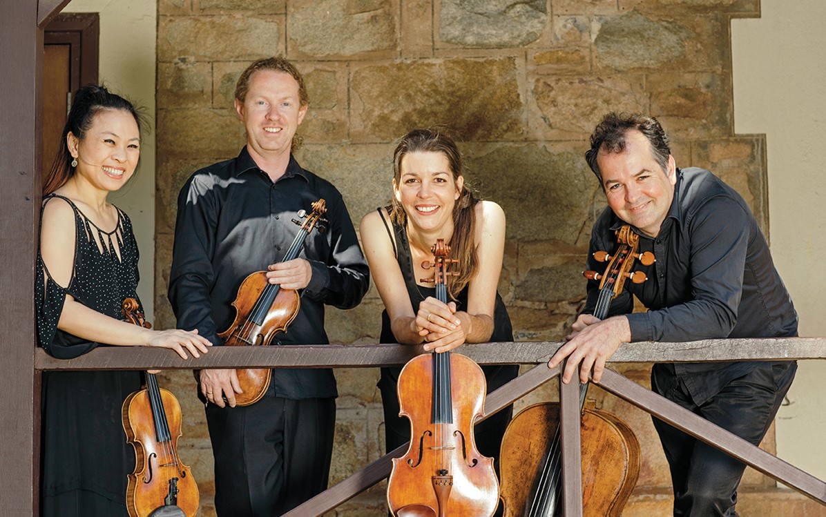 Four musicians holding violins