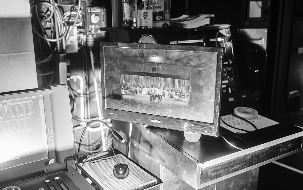 A black and white image of the equipment backstage including the screen showing the stage