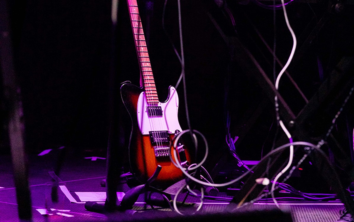 A guitar and cords on stage