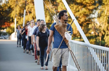 Image of an instructor and audience members walking over a bridge for the interactive walking performance Galup.