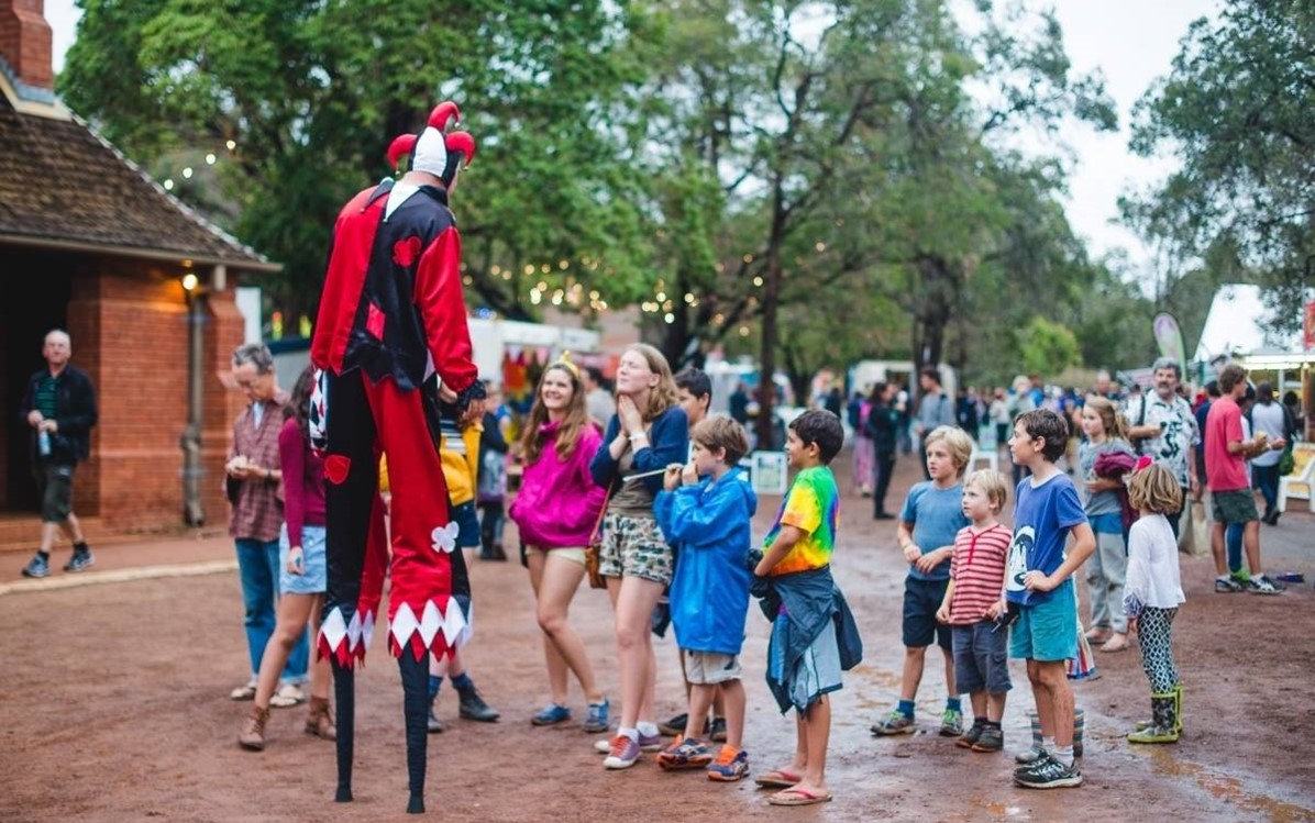 Image of children looking at a clown on stilts at Fairbridge Festival